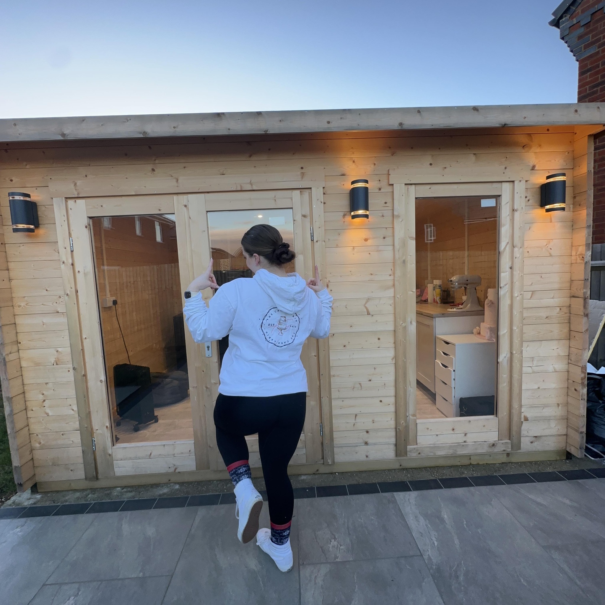 Person jogging toward The Cake Cabin wooden structure