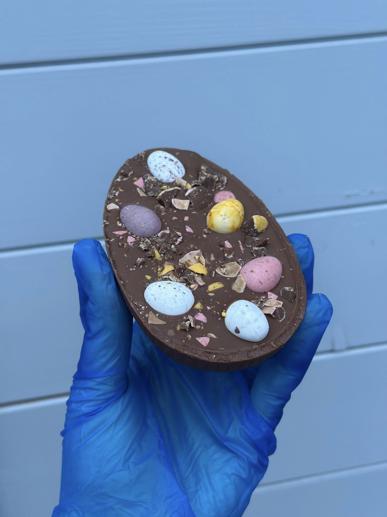 Chocolate Easter egg with colorful candy decorations