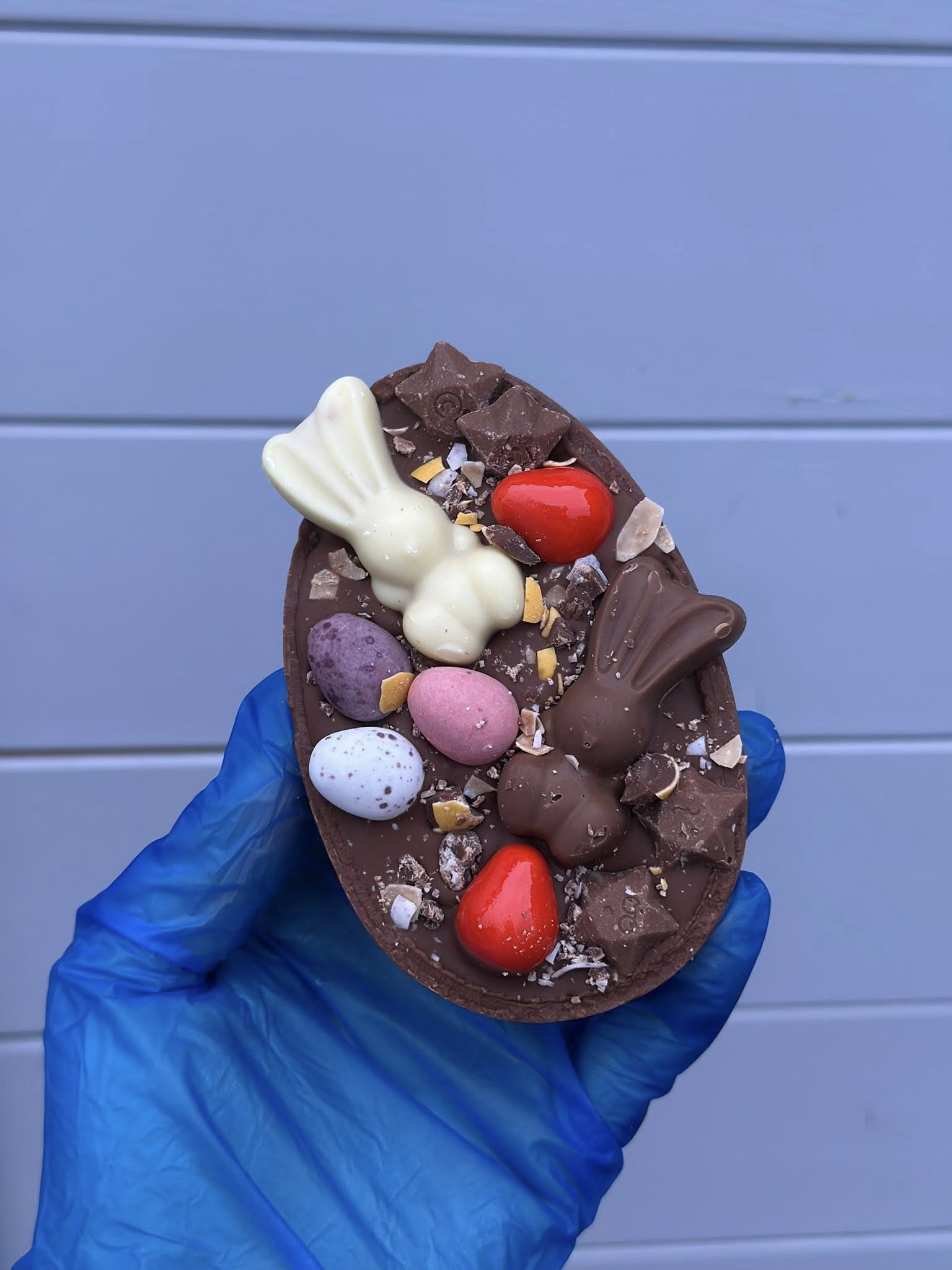 Chocolate Easter egg with white bunny and colorful decorations
