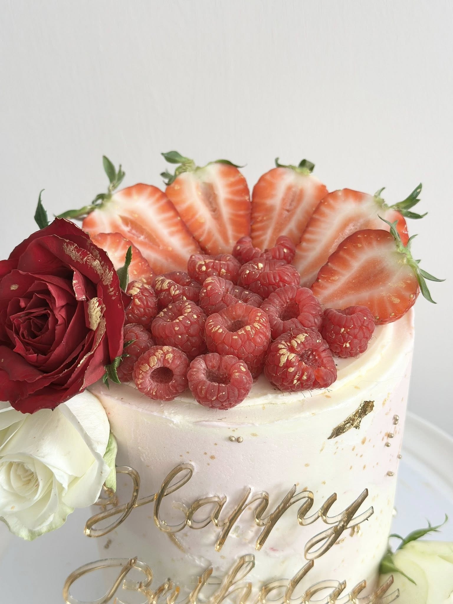 Elegant layered cake with fresh berries and rose