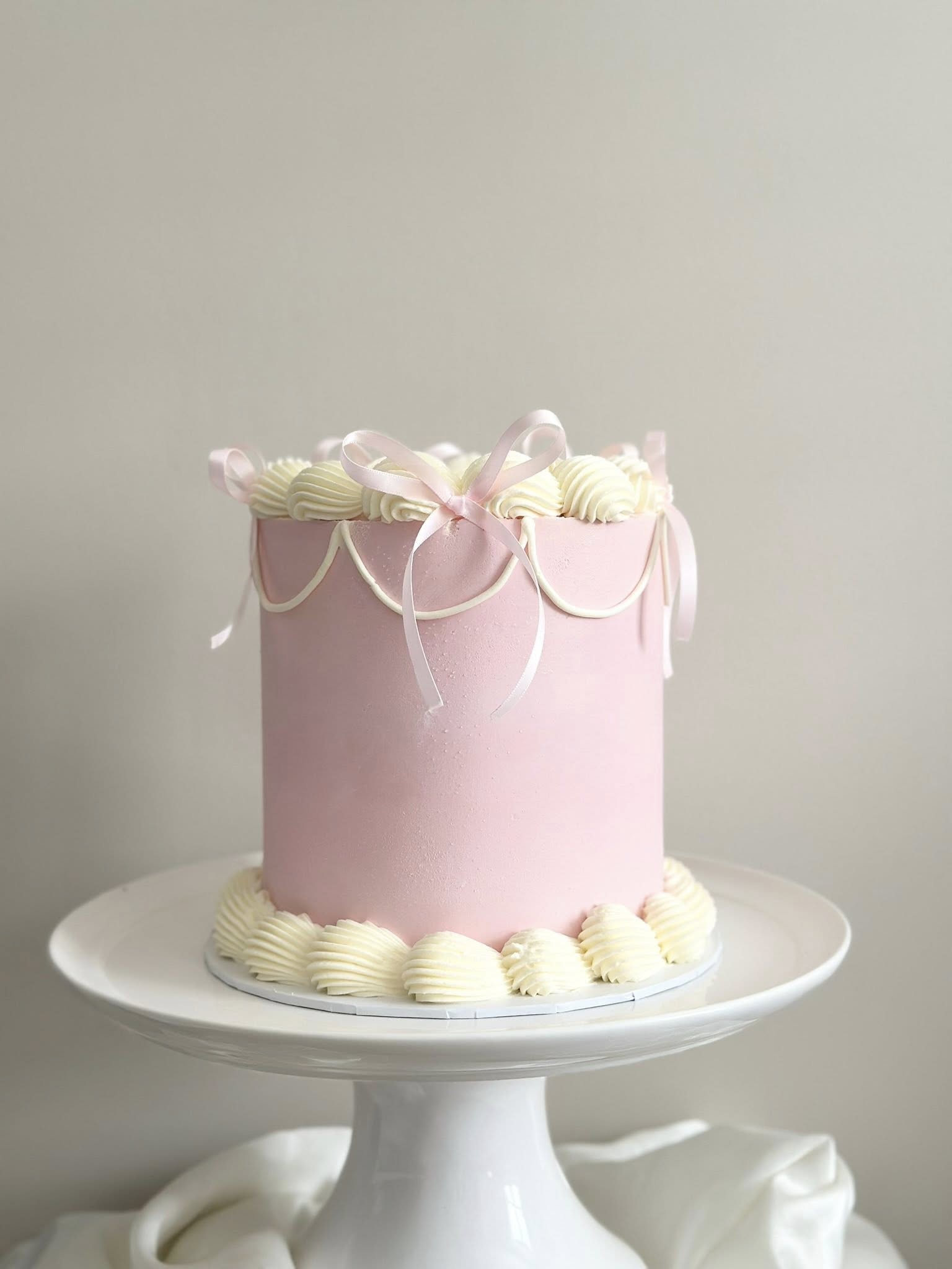 Pink frosted cake with cream piping decoration